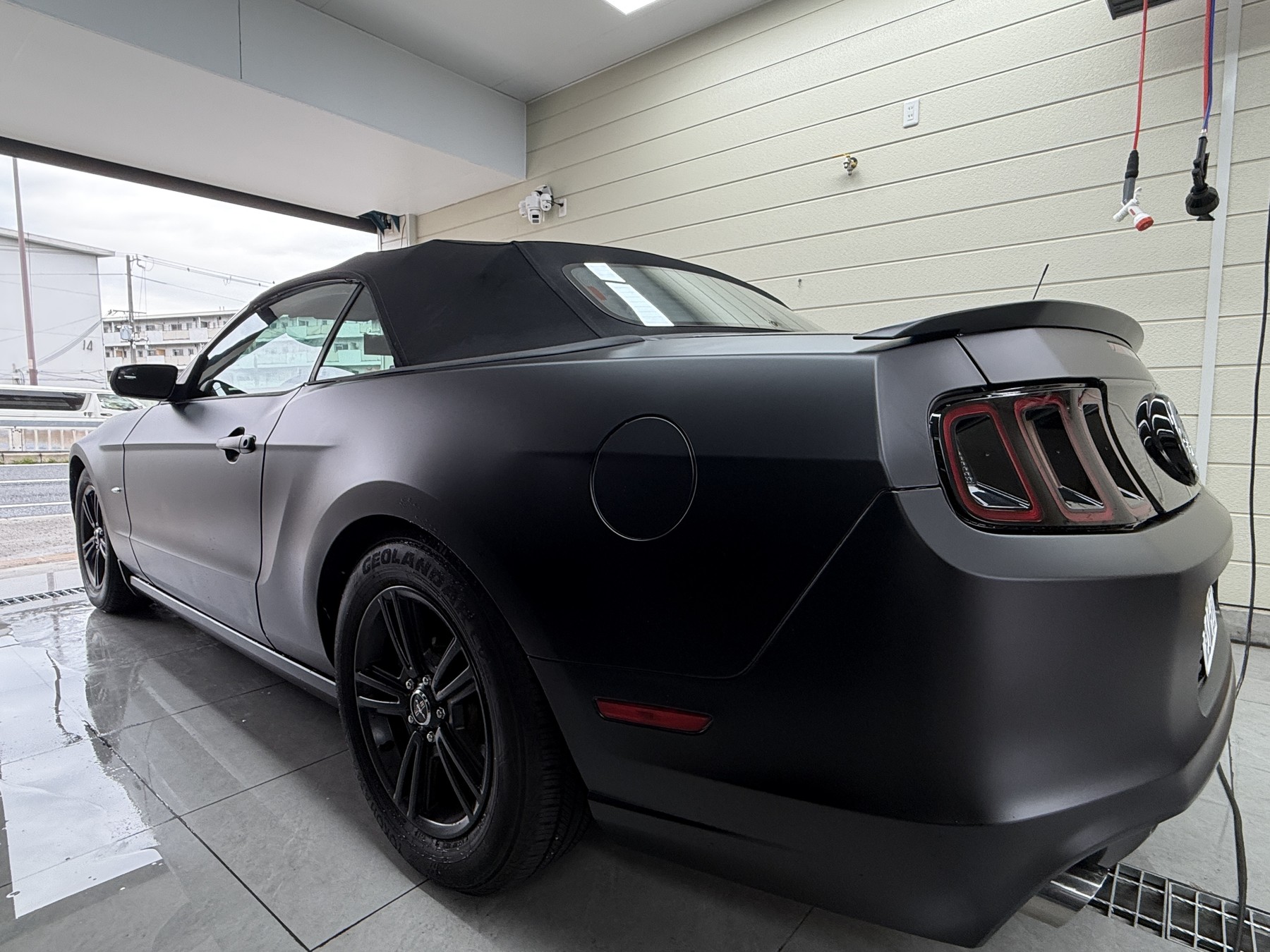 Ford Mustang after satin black wrap, rear three-quarter view